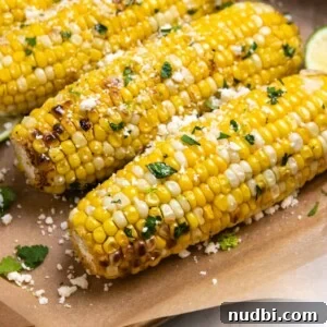 Cilantro lime air fryer corn on the cob sitting on brown parchment.