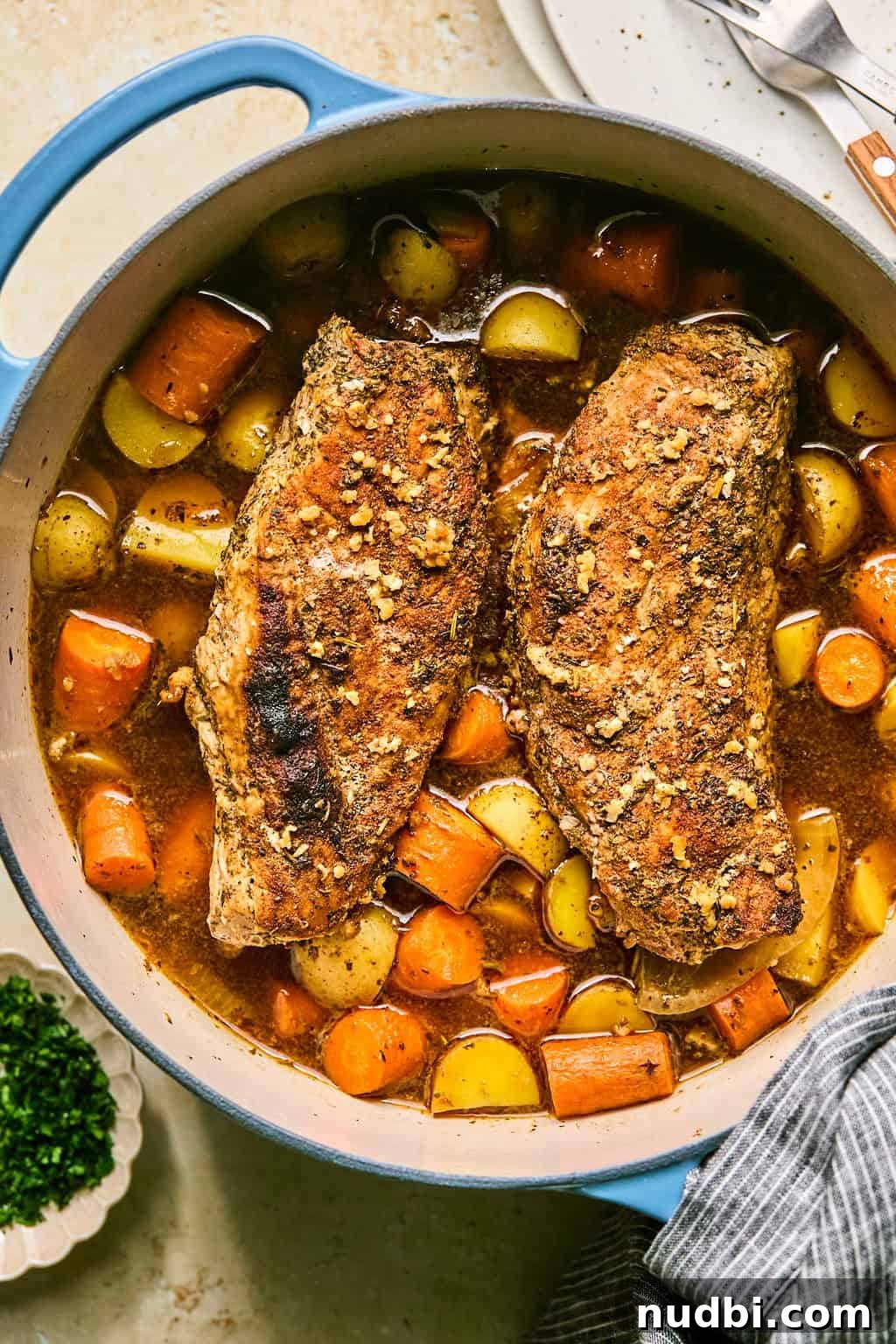 Juicy Pork Tenderloin in a Dutch Oven: Simple Oven-Braised Recipe 2 Honey garlic glazed pork tenderloin in dutch oven pot with carrots and potatoes in pot.