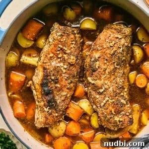 Juicy Pork Tenderloin in a Dutch Oven: Simple Oven-Braised Recipe 11 Dutch oven with roasted pork tenderloin, carrots and potatoes.