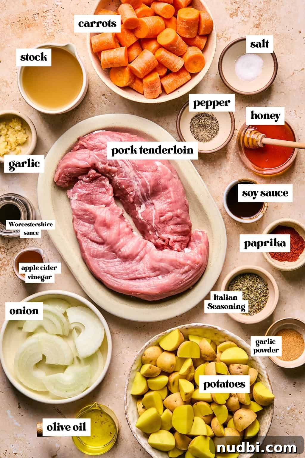 Juicy Pork Tenderloin in a Dutch Oven: Simple Oven-Braised Recipe 3 Labeled ingredients arranged on surface including pork tenderloin, carrots, potatoes, seasoning and more.