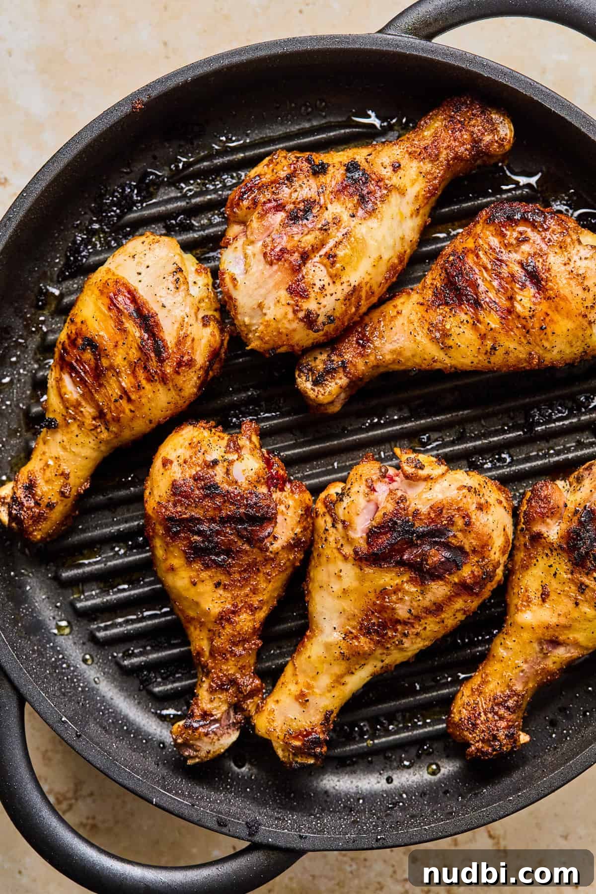 Crispy Grilled Chicken Drumsticks with Smoky BBQ Flavor 9 Grilled chicken legs on indoor grill pan.