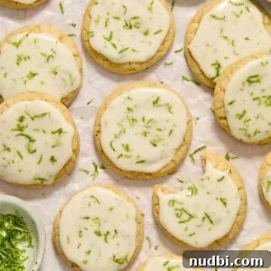 Zesty Key Lime Cookie Recipe for Luscious Citrus Cookies 12 Key lime cookies with lime glaze and zest on surface.