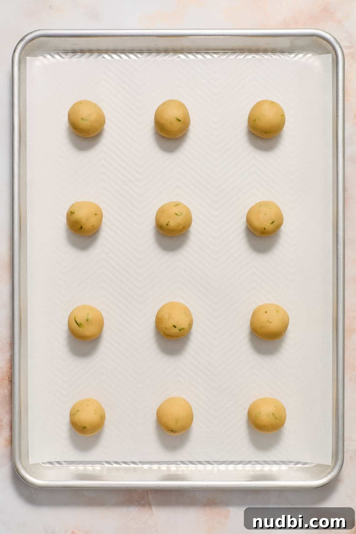 Zesty Key Lime Cookie Recipe for Luscious Citrus Cookies 8 Key lime cookie dough rolled into balls on parchment lined baking sheet.