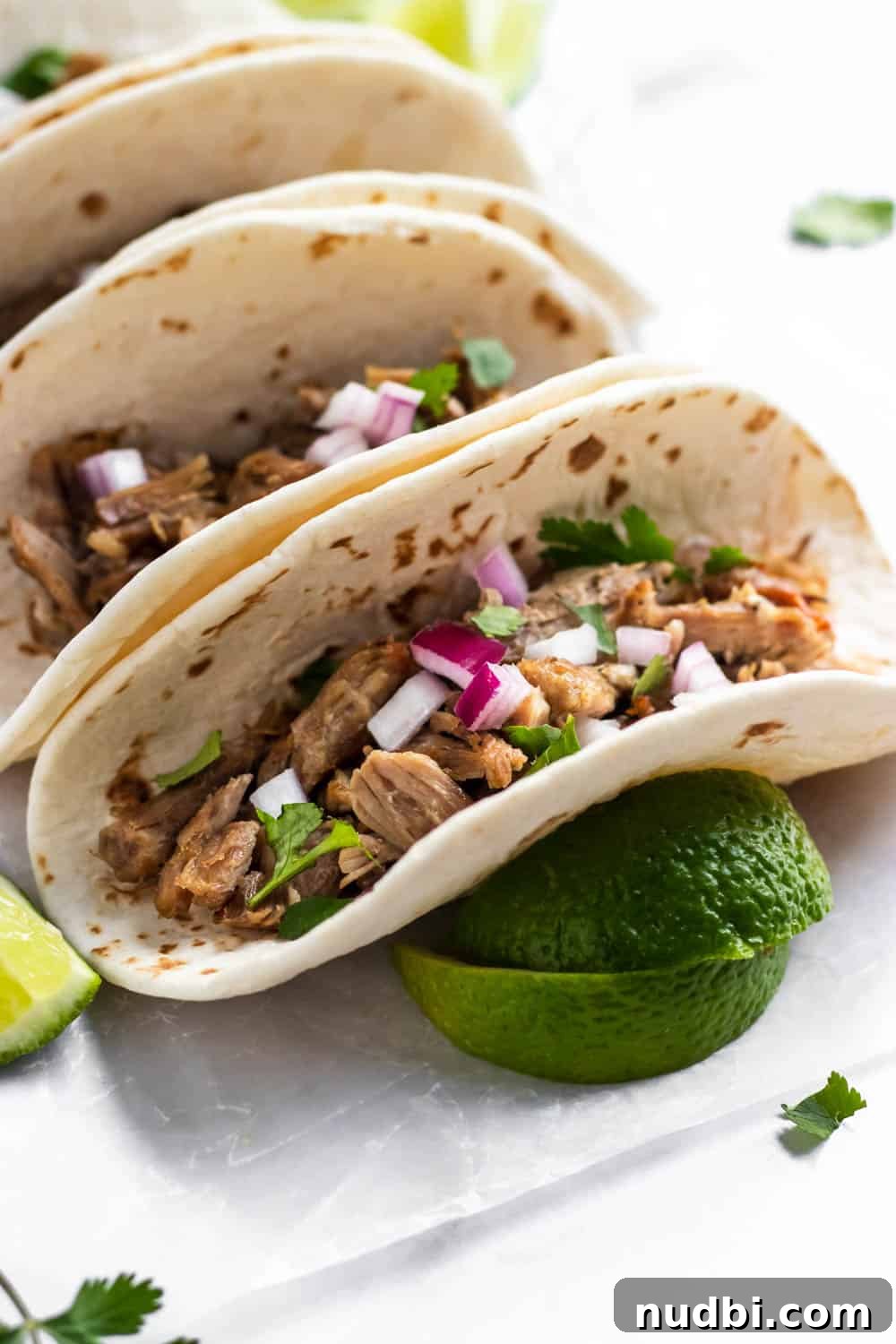 Side Dishes to Serve with Carnitas: 15 Flavor-Packed Pairings 3 Carnitas tacos topped with red onion and cilantro.