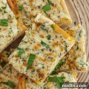 10 Delicious Side Dishes to Serve With Gnocchi 14 Cheesy garlic bread on plate topped with chopped basil.