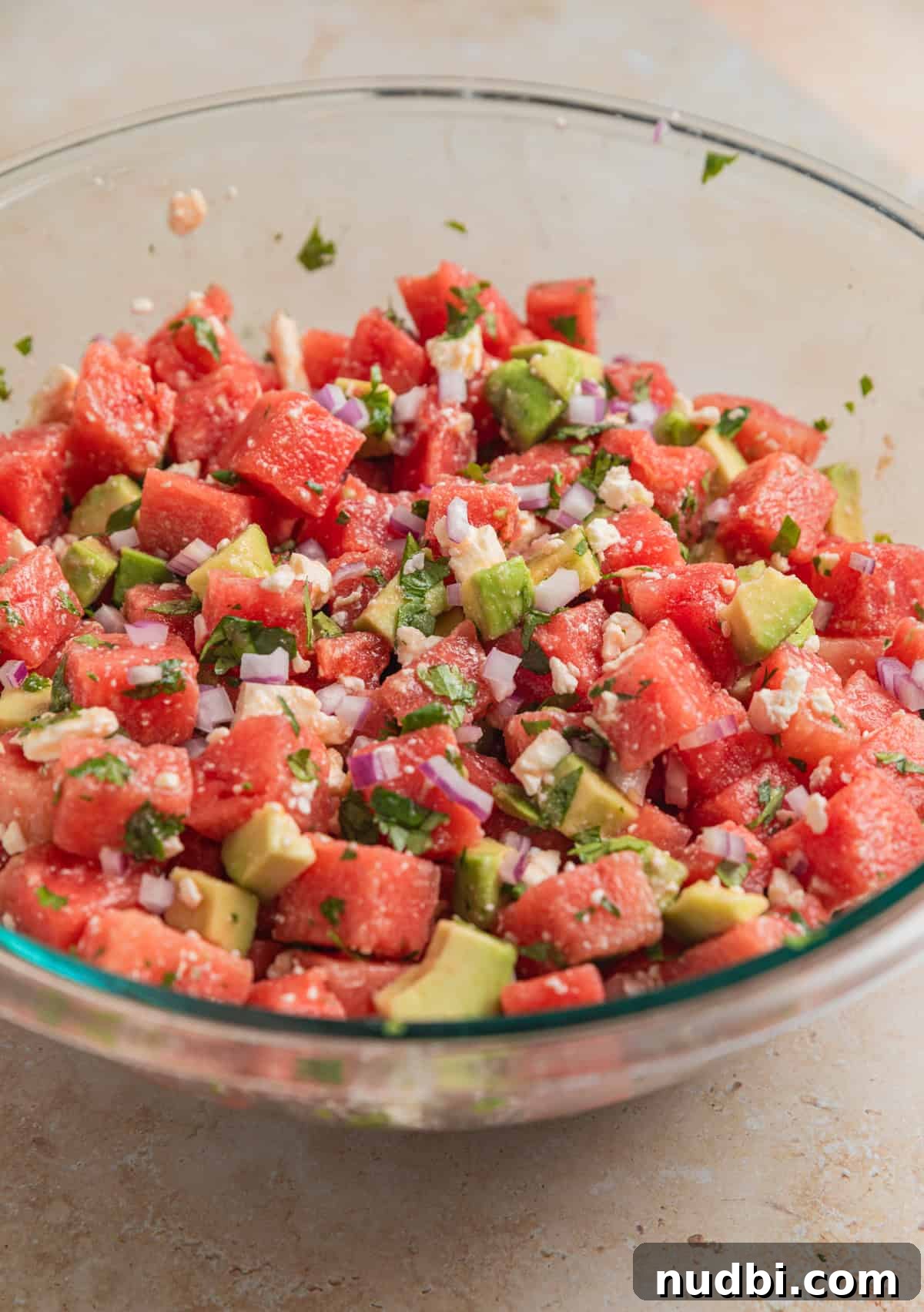 Watermelon and Avocado Salad with Feta and Mint 7 Watermelon avocado salad tossed in large glass bowl.