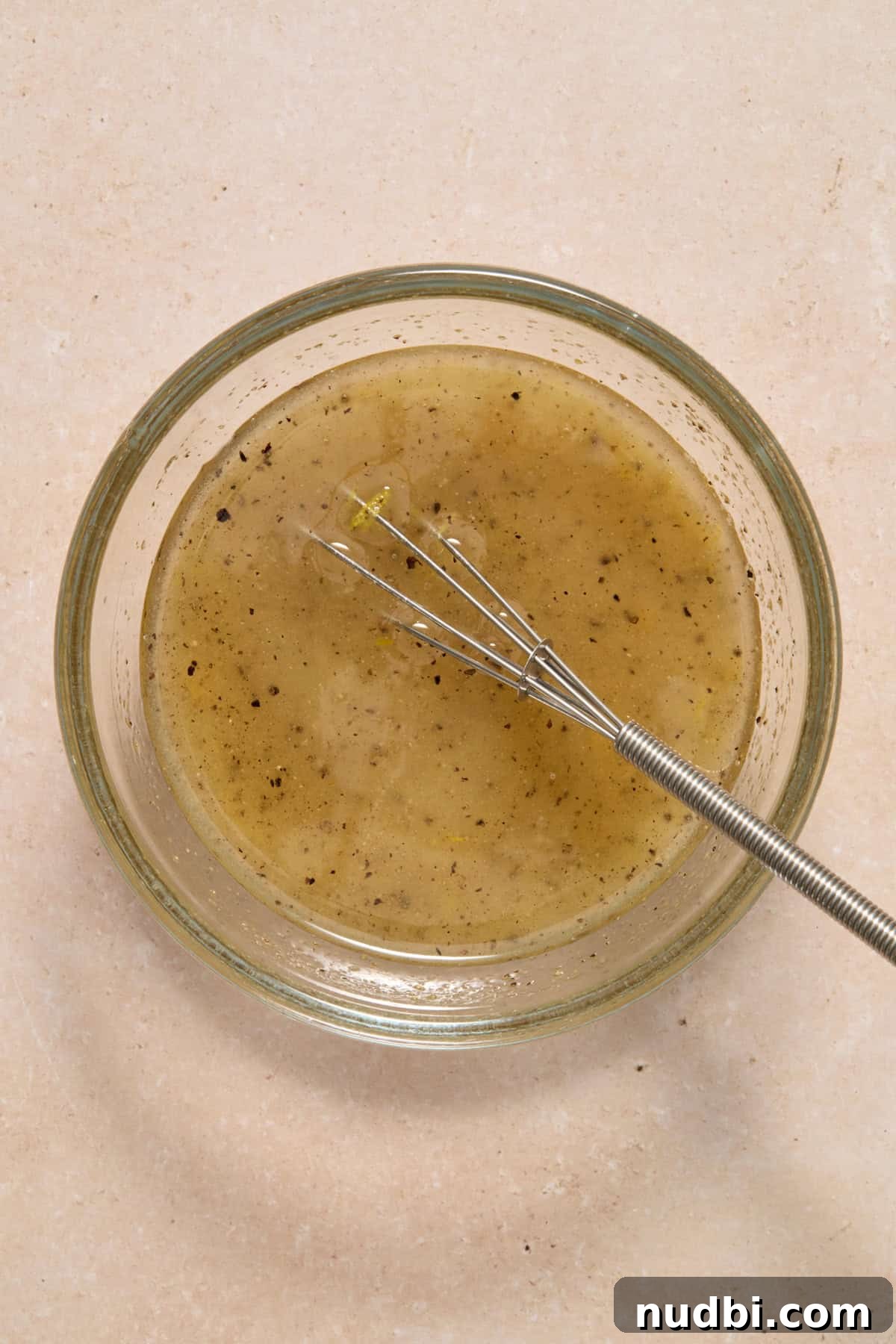 Lemon Pepper Grilled Chicken Recipe – Zesty Weeknight Dinner 4 Lemon marinade in glass bowl with whisk.