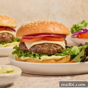 Juicy Mozzarella-Stuffed Burgers with Garlic Herb Buns 12 Mozzarella burger on bun with toppings on plate with simple salad.