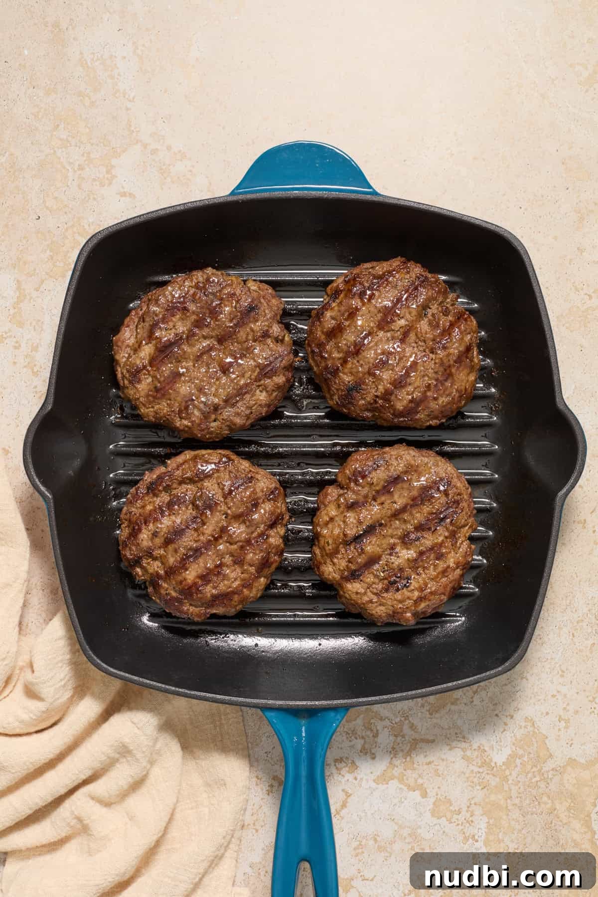 Juicy Mozzarella-Stuffed Burgers with Garlic Herb Buns 10 Cooked burgers in burger pan.