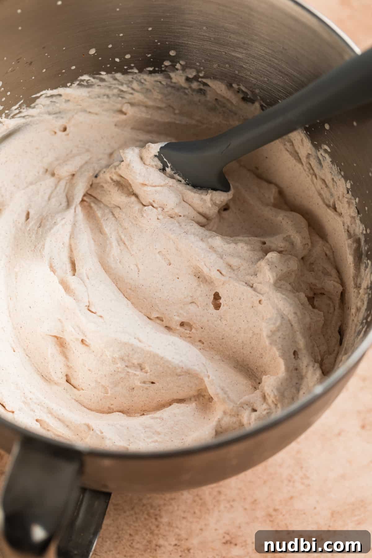 Pumpkin Spice Whipped Cream Recipe — Light & Fluffy Topping 5 Whipped cream in standing mixer bowl with pumpkin spice mixed in.