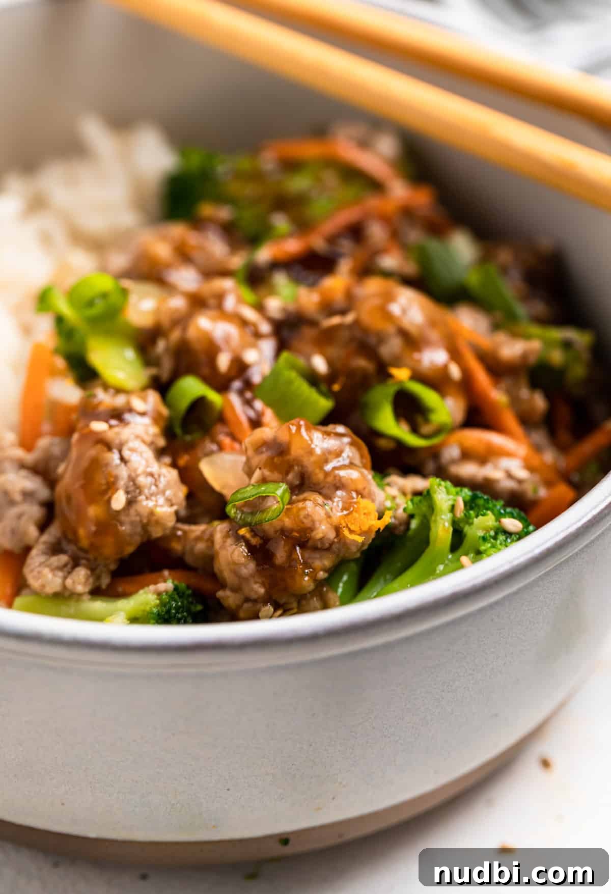 Savory Teriyaki Ground Pork Stir-Fry with Vegetables 2 Bowl with ground pork teriyaki stir fry topped with sesame seeds and chopsticks on top of bowl.