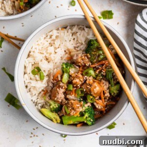 Savory Teriyaki Ground Pork Stir-Fry with Vegetables 12 Teriyaki ground pork stir fry in bowl with white rice and chopsticks.