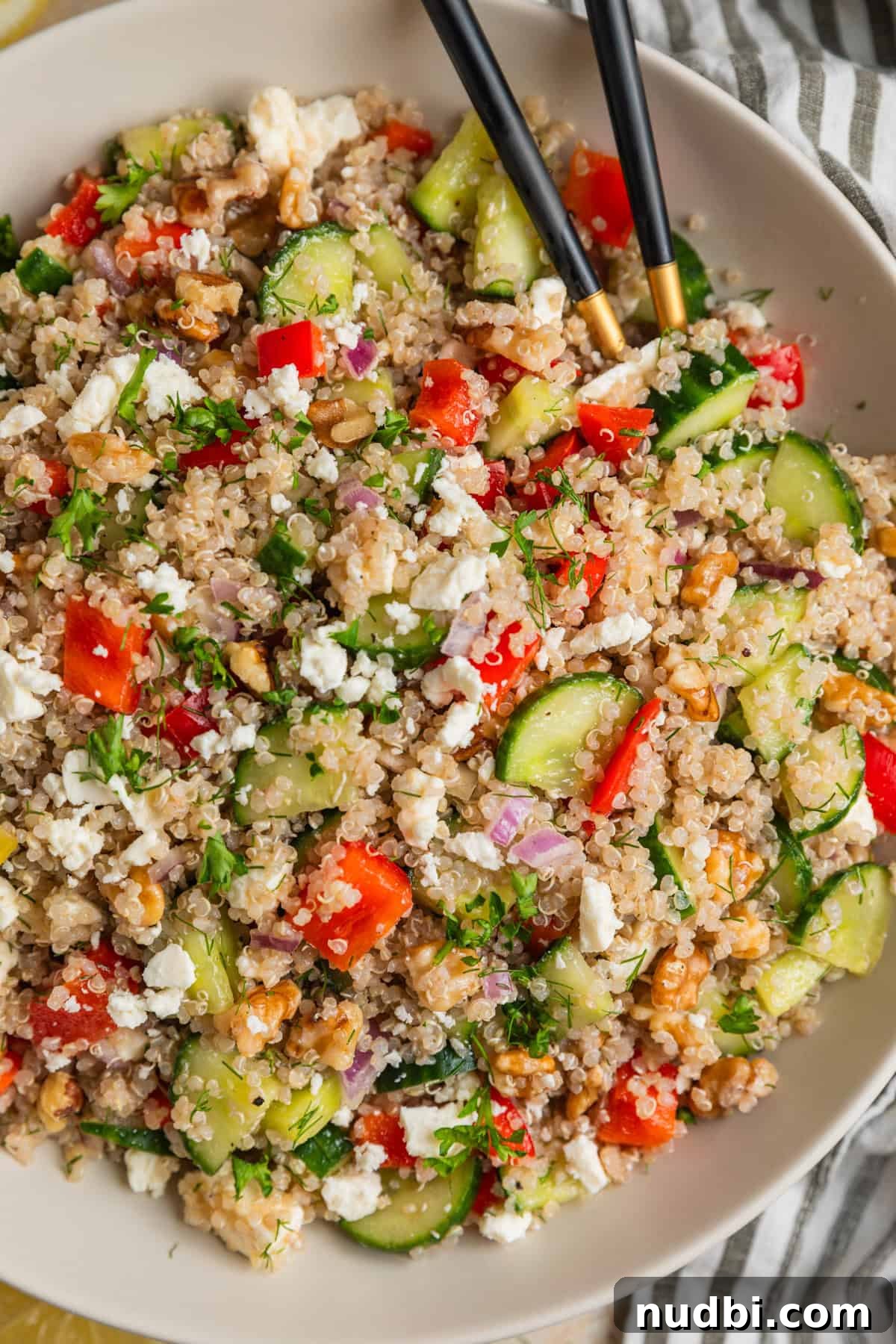 Cucumber Quinoa Salad with Feta and Lemon-Dill Dressing 2 Large bowl with quinoa salad with cucumbers, feta cheese, red pepper, onion, and other ingredients.