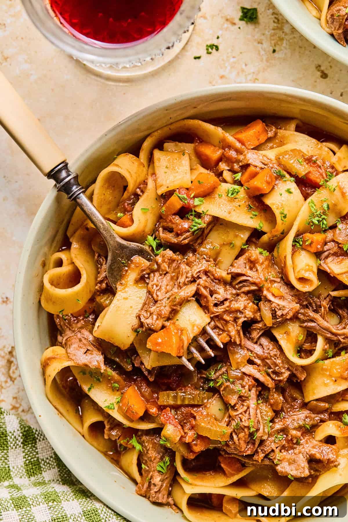 Slow-Cooked Short Rib Ragu Recipe for Tender Pasta Nights 2 Bowl with slow cooker short rib ragu and fork scooping in.