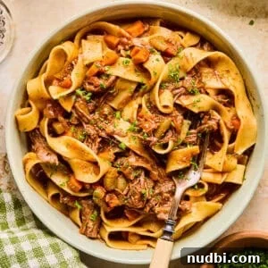 Slow-Cooked Short Rib Ragu Recipe for Tender Pasta Nights 13 Bowl with short rib ragu tossed with pasta and chopped fresh parsley over top.