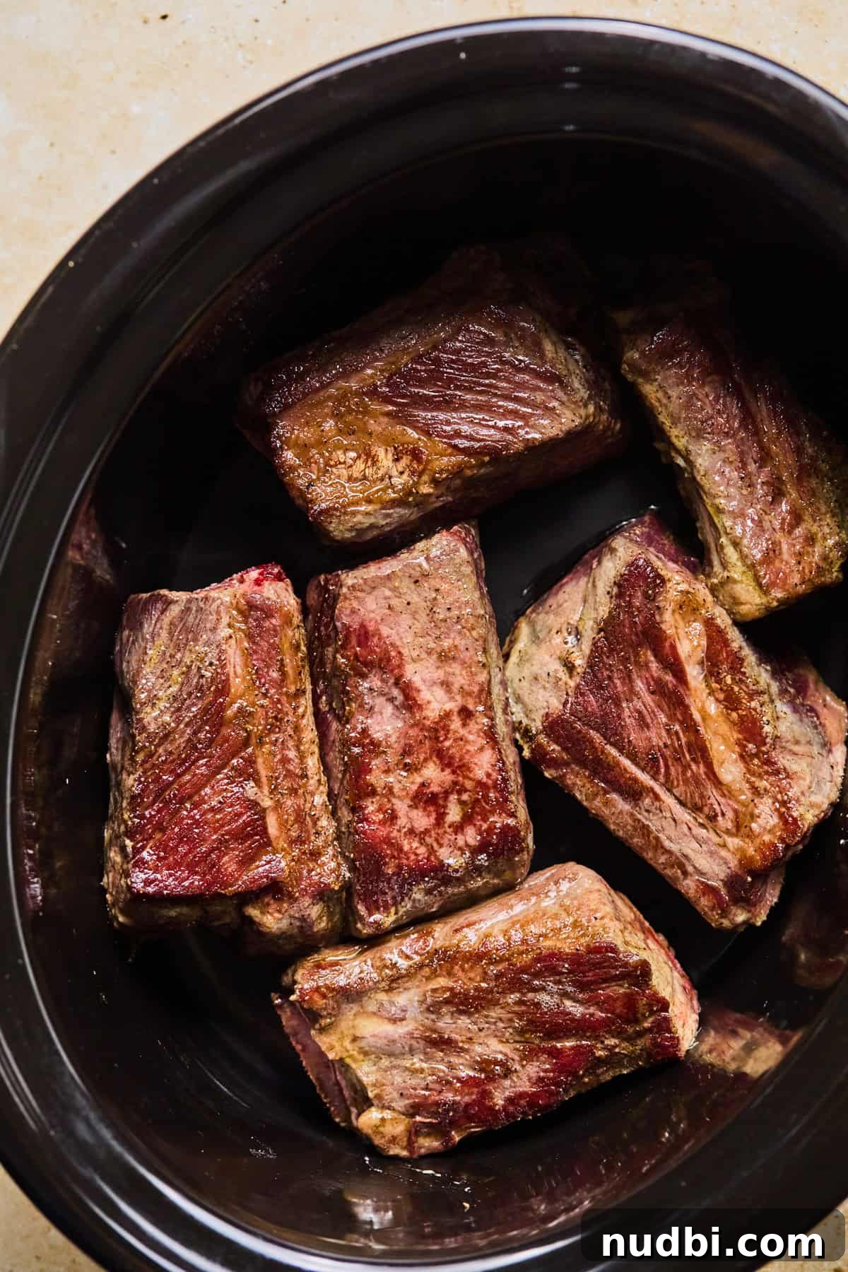 Slow-Cooked Short Rib Ragu Recipe for Tender Pasta Nights 6 Crockpot with seared short ribs arranged in the bottom of the pot.