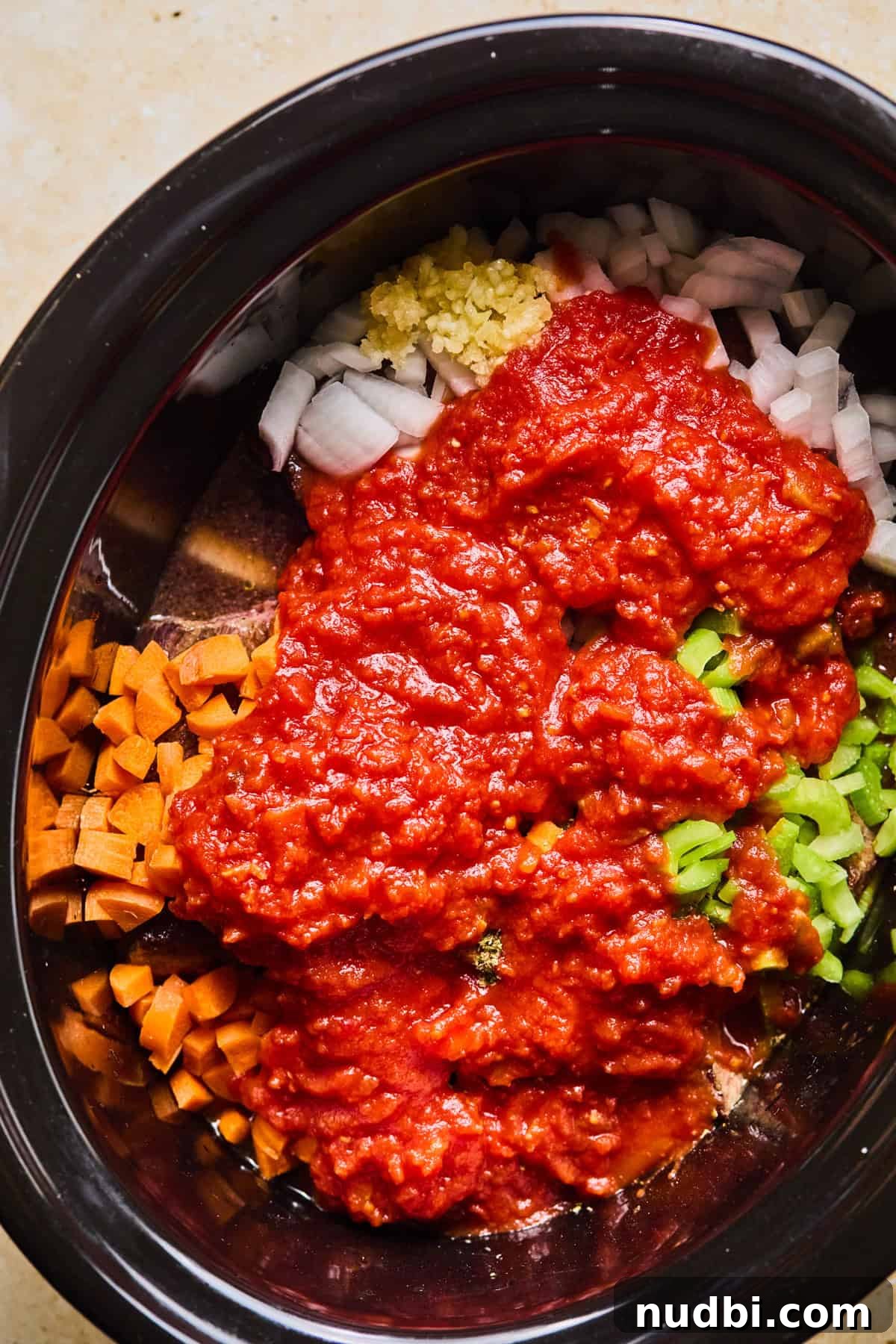 Slow-Cooked Short Rib Ragu Recipe for Tender Pasta Nights 7 Slow cooker with ragu ingredients over top of meat before cooking.