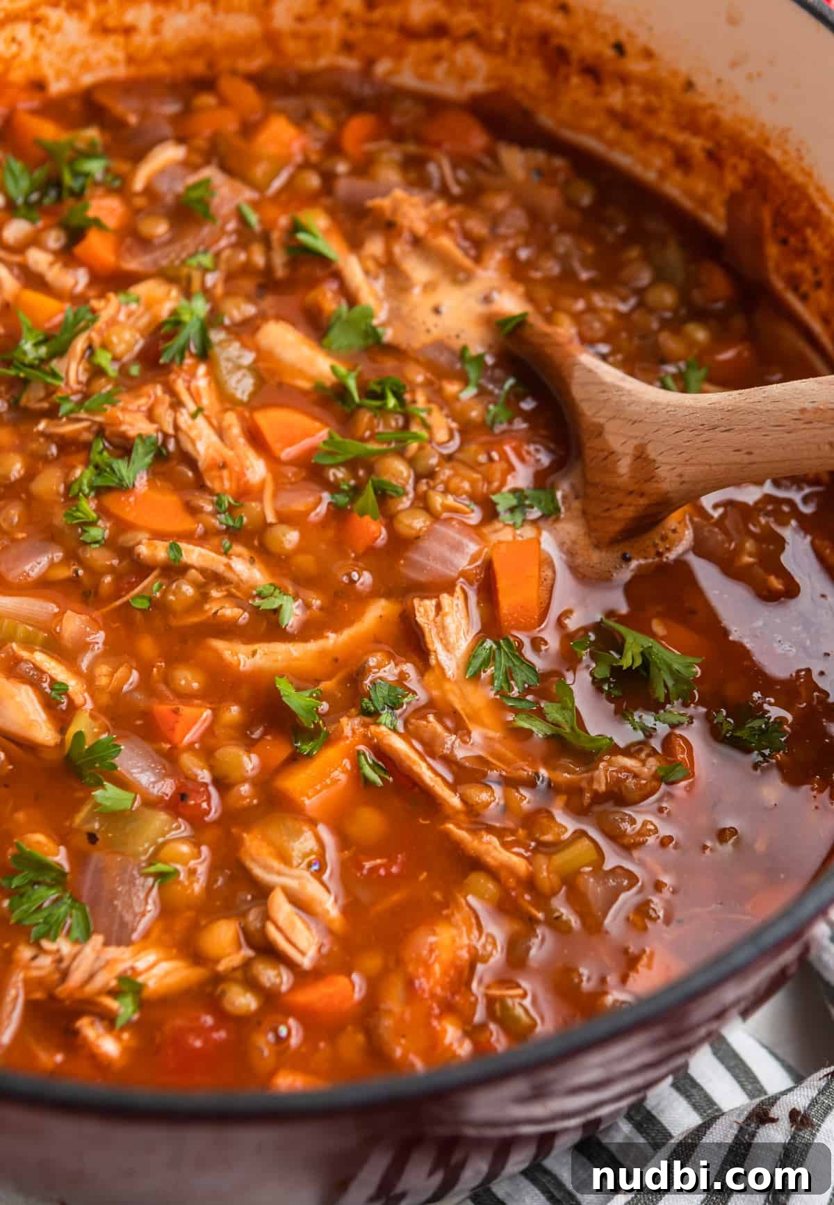 Hearty Turkey and Lentil Soup Recipe for Weeknight Dinners 7 Soup pot with cooked turkey lentil soup and wood spoon.