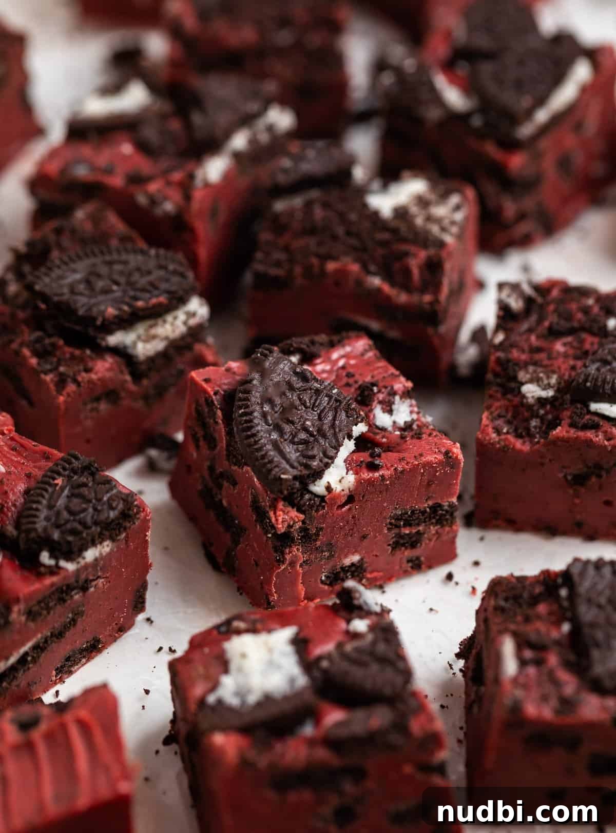 Decadent Red Velvet Oreo Fudge Recipe for Chocolate Lovers 2 Red velvet fudge with Oeos sitting on wax paper.