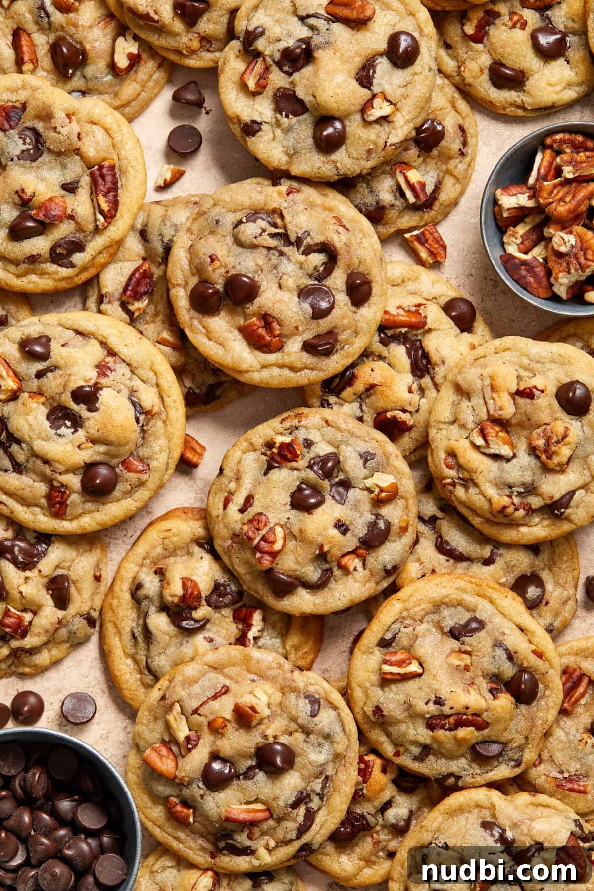 Chewy Chocolate Chip Pecan Cookies Recipe 9 Chocolate chip cookies with pecans added along with bowl of chocolate chips and pecans beside.