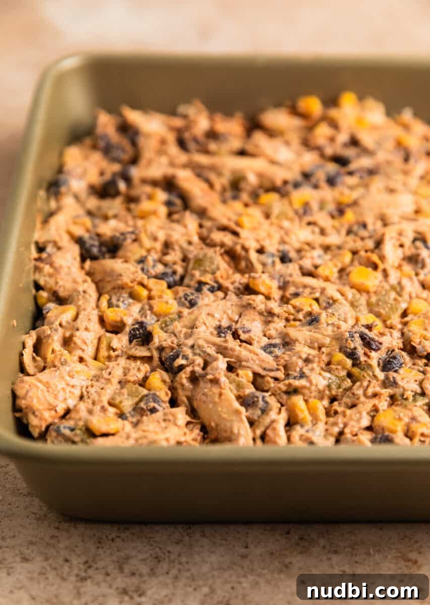 Cheesy Chicken Taco Casserole Bake with Crispy Tortilla Topping 5 Chicken taco casserole mixture in baking pan.