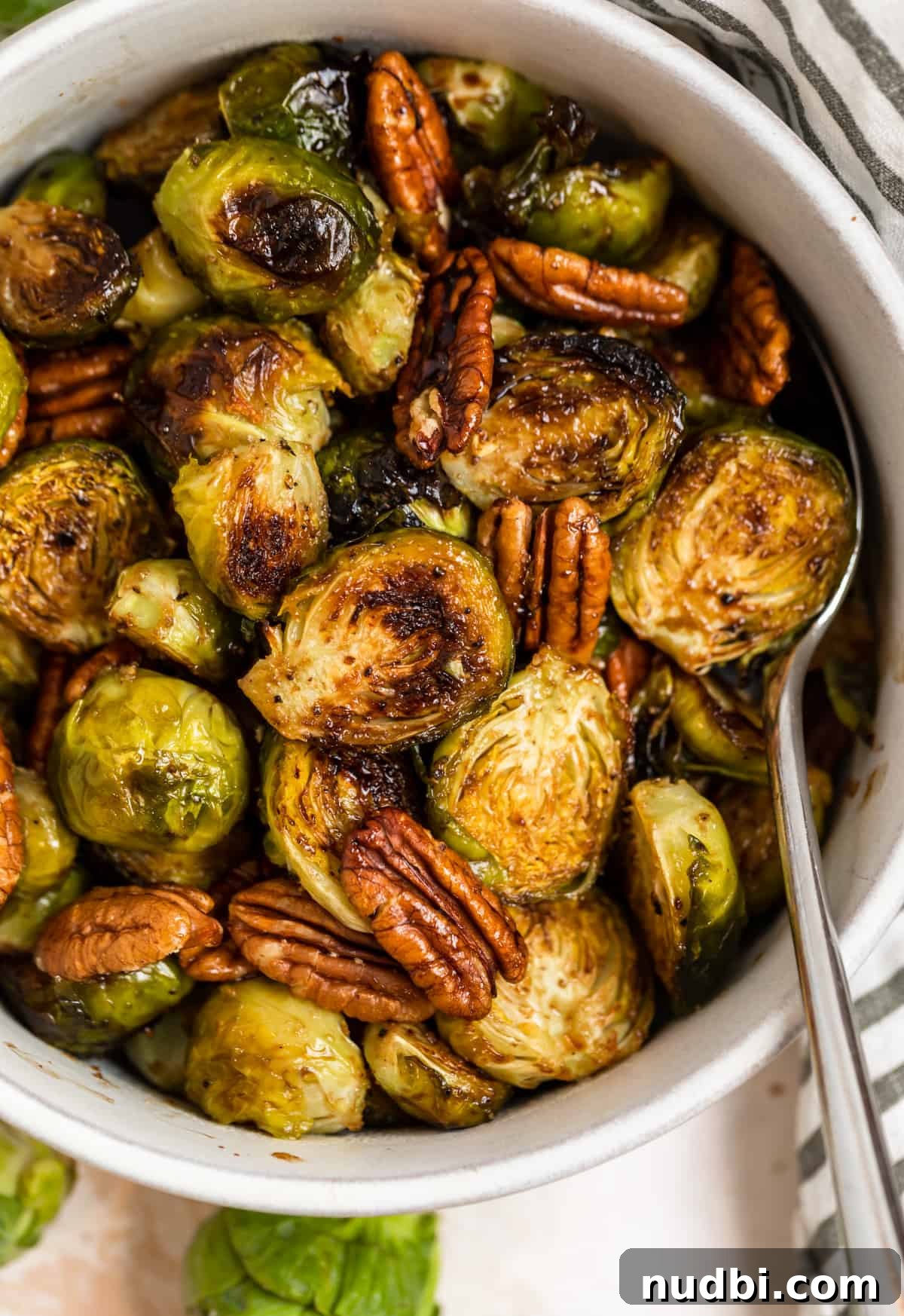 25 Delicious Pairings for Brussels Sprouts to Complete Any Meal 2 Roasted maple balsamic brussels sprouts in dish with pecans.