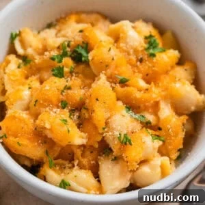 Bowl with protein mac and cheese with chopped parsley over top.