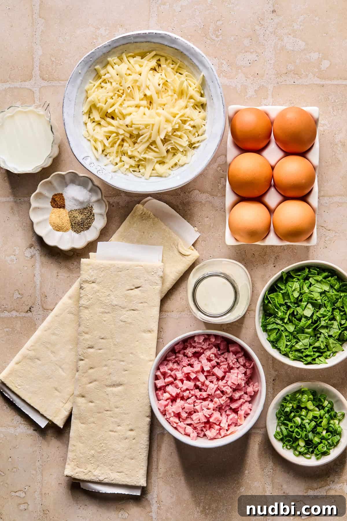 Flaky Puff Pastry Quiche Recipe: Quick Savory Tart for Brunch 4 Eggs, shredded cheese, puff pastry and other ingredients on surface.