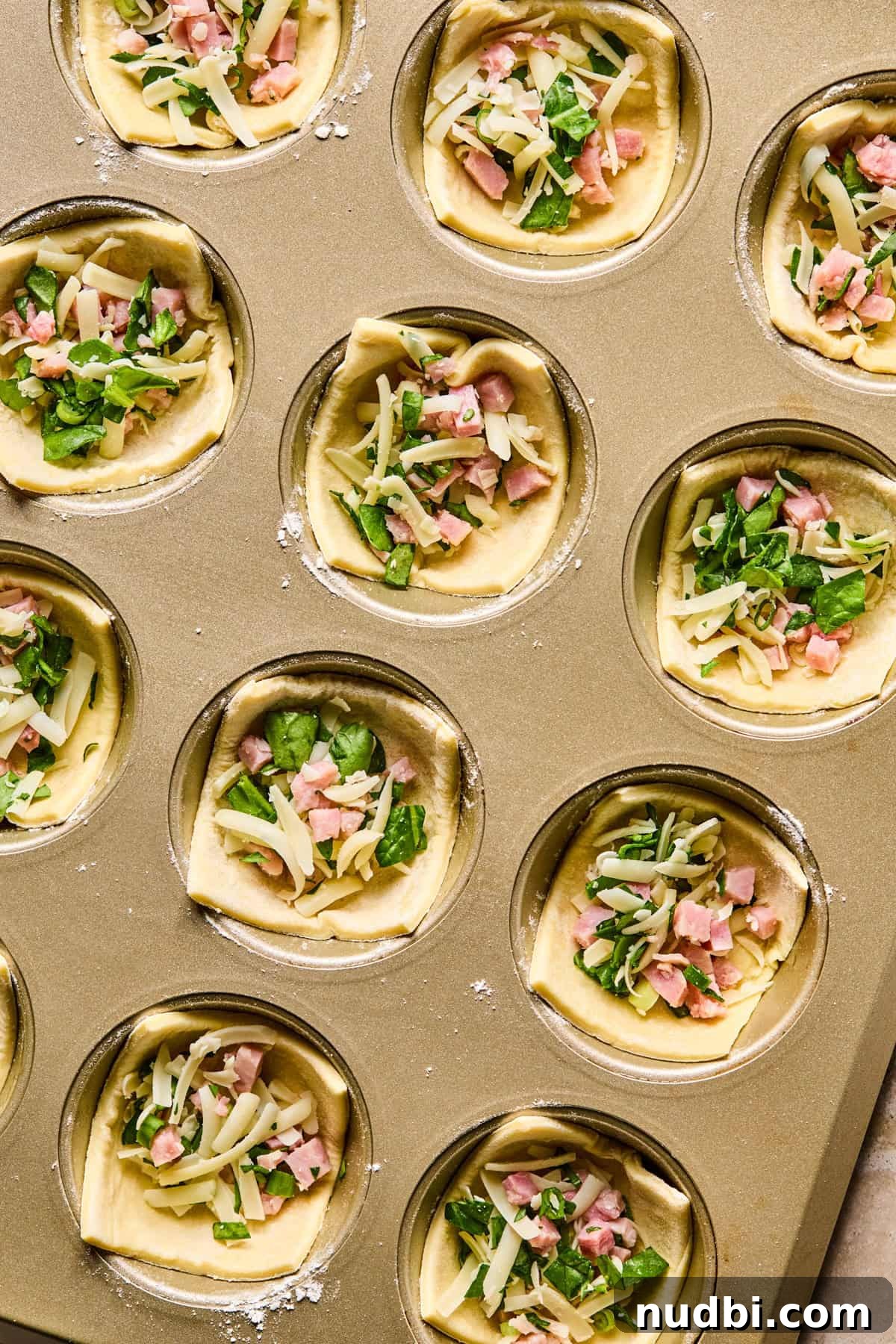 Flaky Puff Pastry Quiche Recipe: Quick Savory Tart for Brunch 8 Puff pastry squares in muffin tin filled with ham, cheese and spinach.