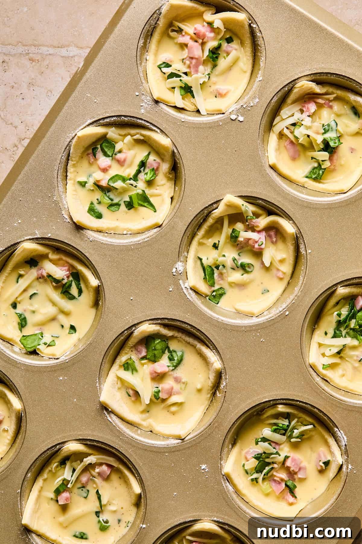 Flaky Puff Pastry Quiche Recipe: Quick Savory Tart for Brunch 9 Egg filled puff pastry cups in muffin tin.