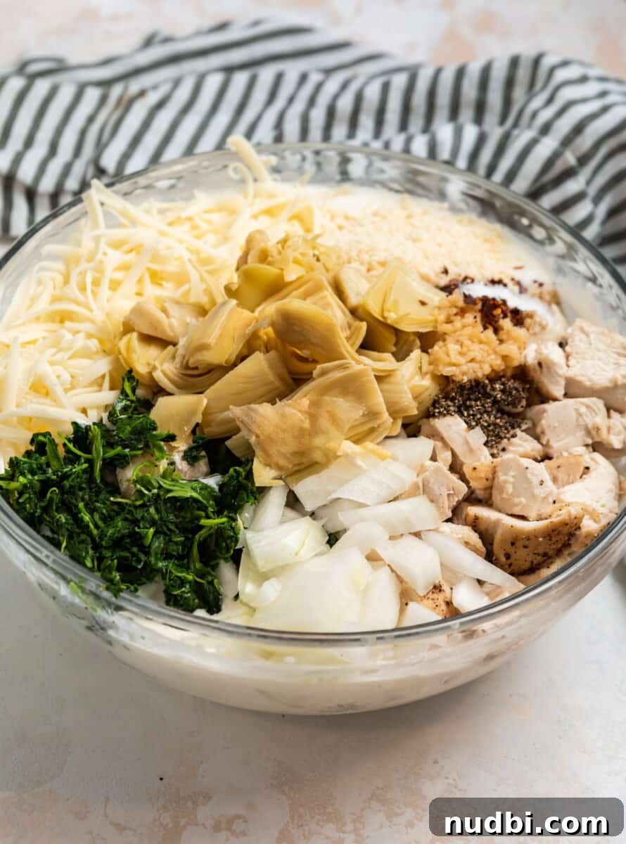 Spinach and Artichoke Chicken Casserole Recipe 4 Spinach, artichokes, chicken, onion, cheese and other ingredients in mixing bowl.