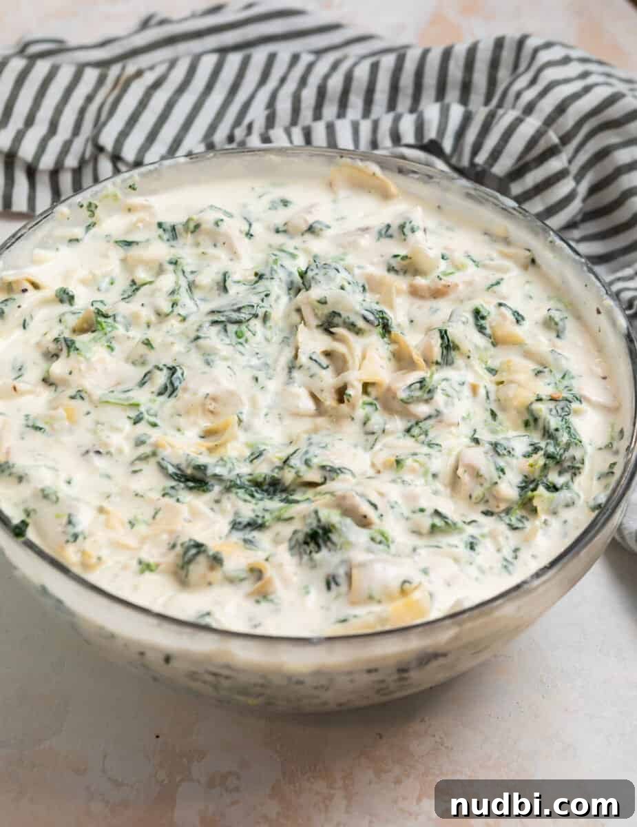 Spinach and Artichoke Chicken Casserole Recipe 5 Spinach artichoke chicken creamy mixture in glass mixing bowl.