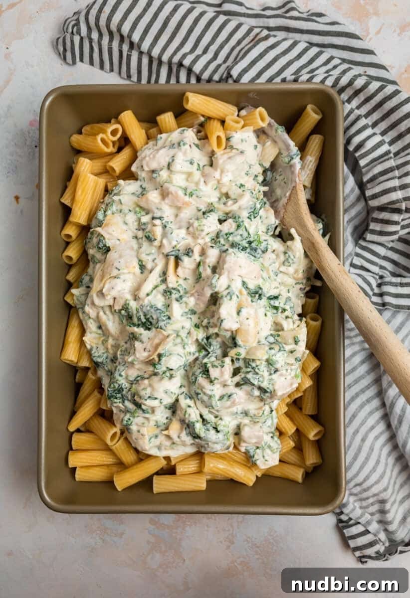 Spinach and Artichoke Chicken Casserole Recipe 7 Spinach artichoke and chicken mixture over past in pan.
