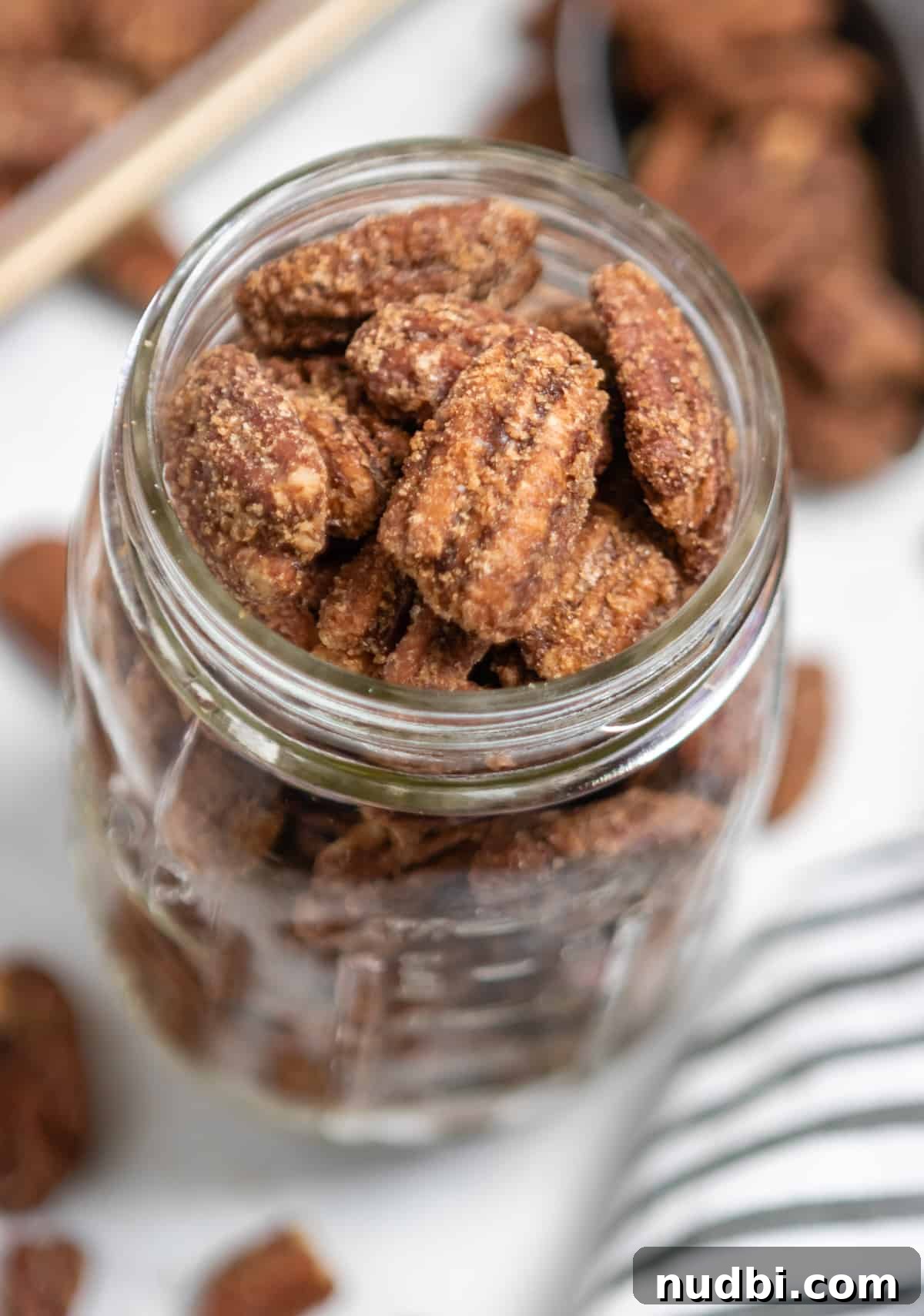 Candied Pumpkin Spice Pecans Made in a Slow Cooker 6 Pumpkin spiced pecans in ball jar with pecans surrounding.