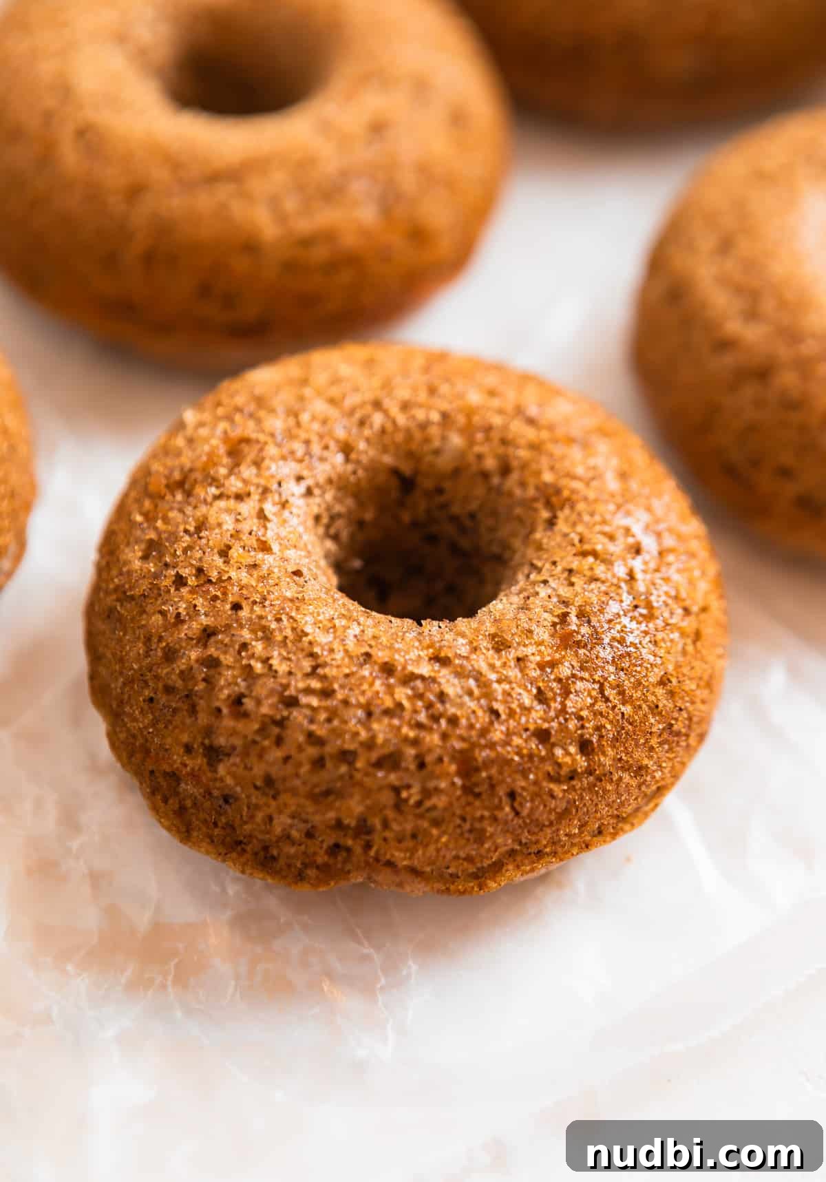 Carrot Cake Donuts with Cream Cheese Glaze: Moist Spiced Recipe 8 Baked carrot cake donut on wax paper.