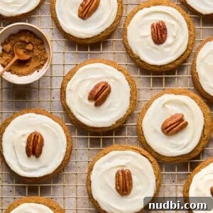 Pumpkin Spice Molasses Cookies Recipe with Warm Autumn Flavor 17 Iced molasses cookies with pecan half on top arranged on cooling rack.