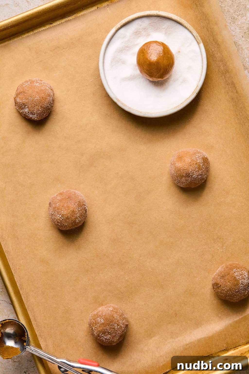 Pumpkin Spice Molasses Cookies Recipe with Warm Autumn Flavor 9 Rolled pumpkin spice cookies on parchment before baking.