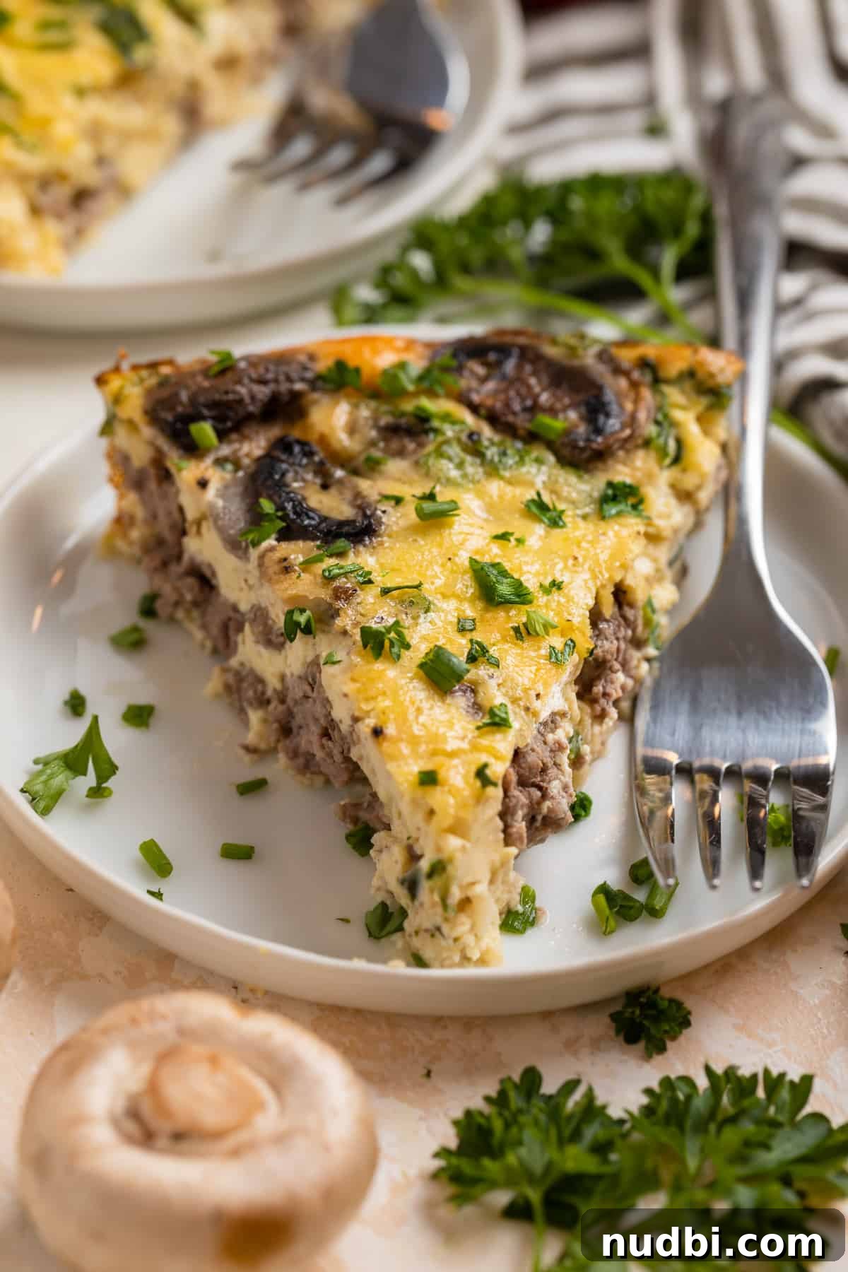 Savory Crustless Mushroom and Cheese Quiche Recipe 3 Mushroom swiss and beef quiche on plate with fork.