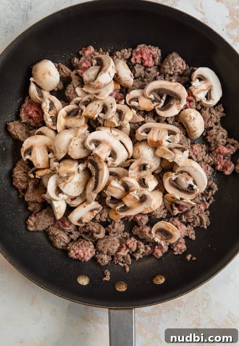 Savory Crustless Mushroom and Cheese Quiche Recipe 4 Browned ground beef with fresh mushrooms added to skillet.
