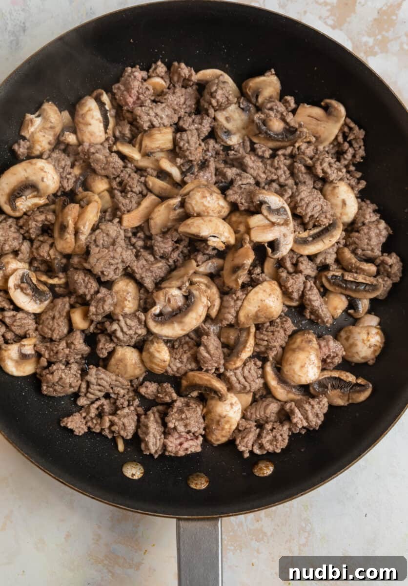 Savory Crustless Mushroom and Cheese Quiche Recipe 5 Browned mushrooms and beef in skillet.