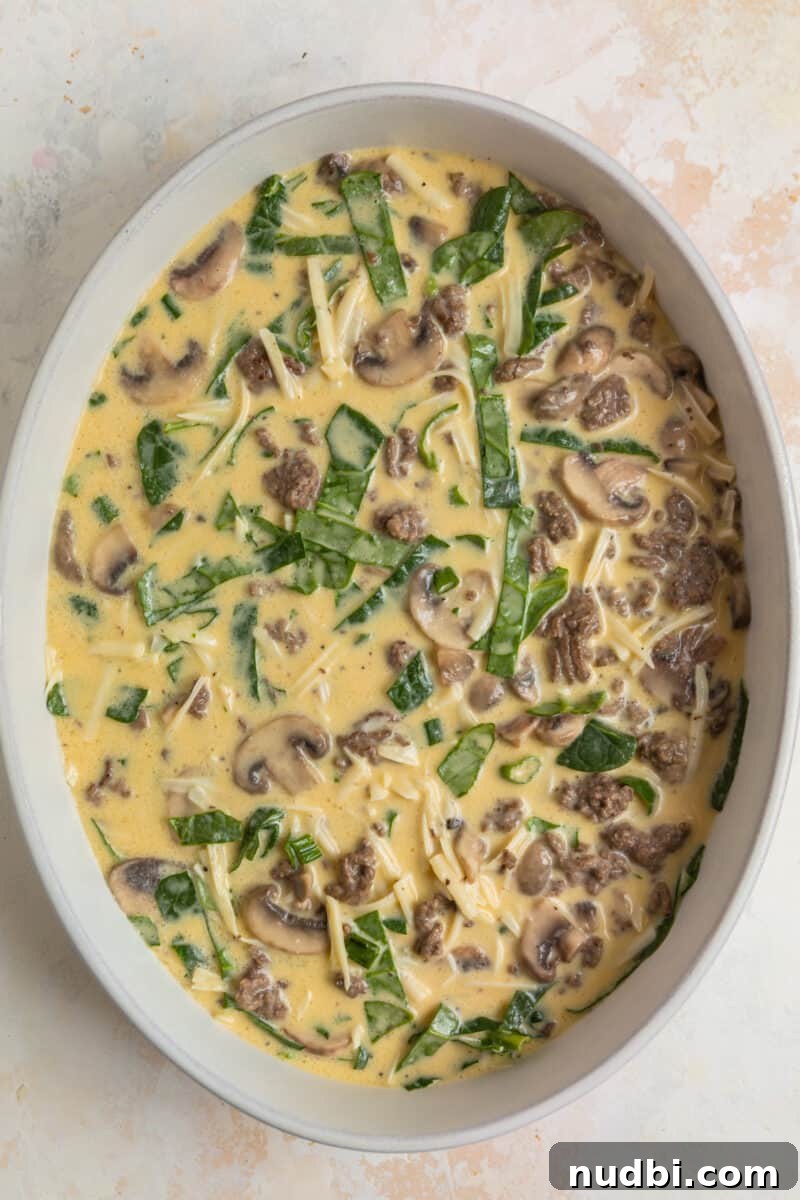 Savory Crustless Mushroom and Cheese Quiche Recipe 8 Crustless mushroom quiche with swiss and beef in dish before baking.