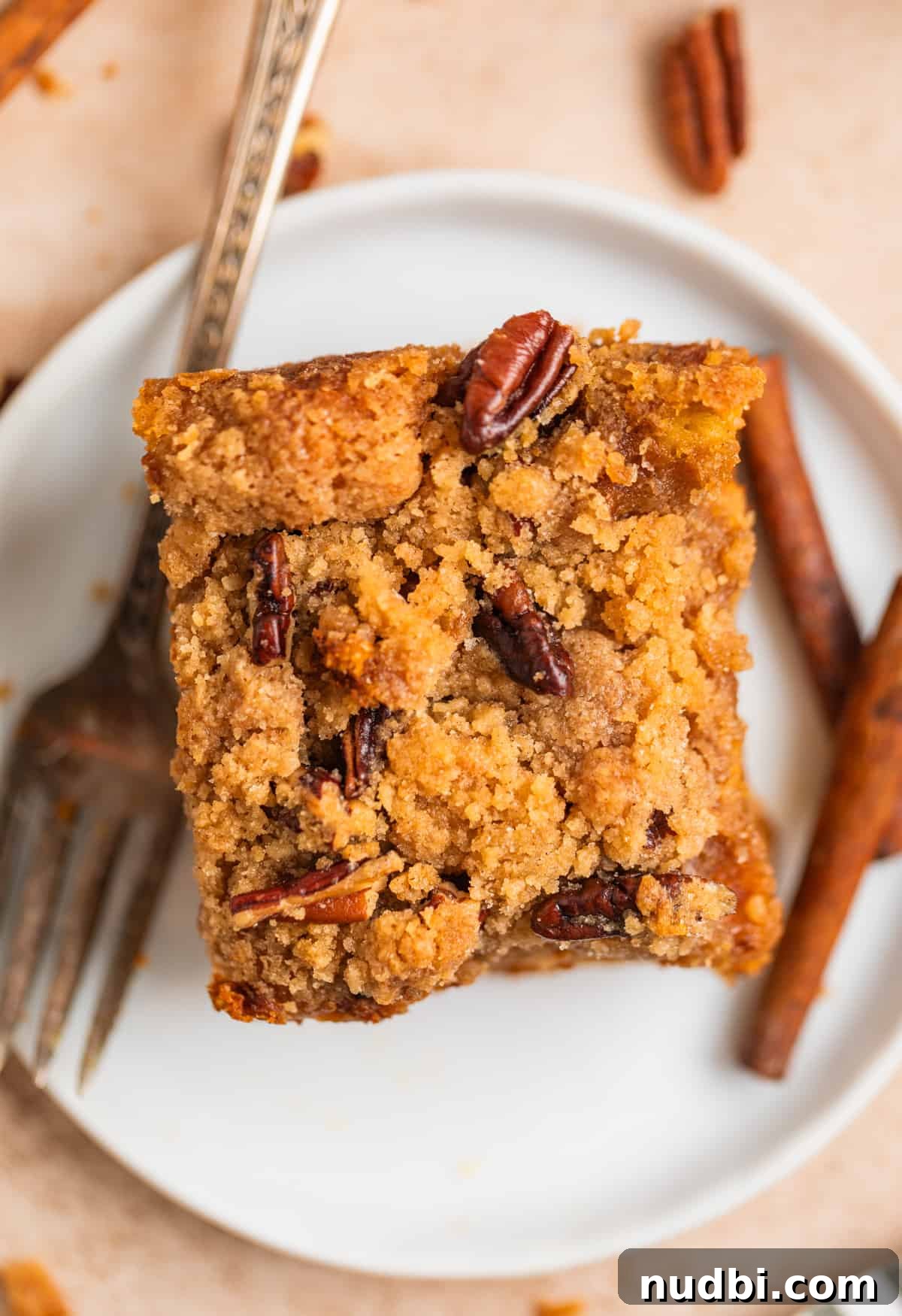 Pumpkin Spice French Toast Casserole Recipe for Fall Brunch 11 Slice of streusel topped pumpkin baked french toast on white dish with fork.