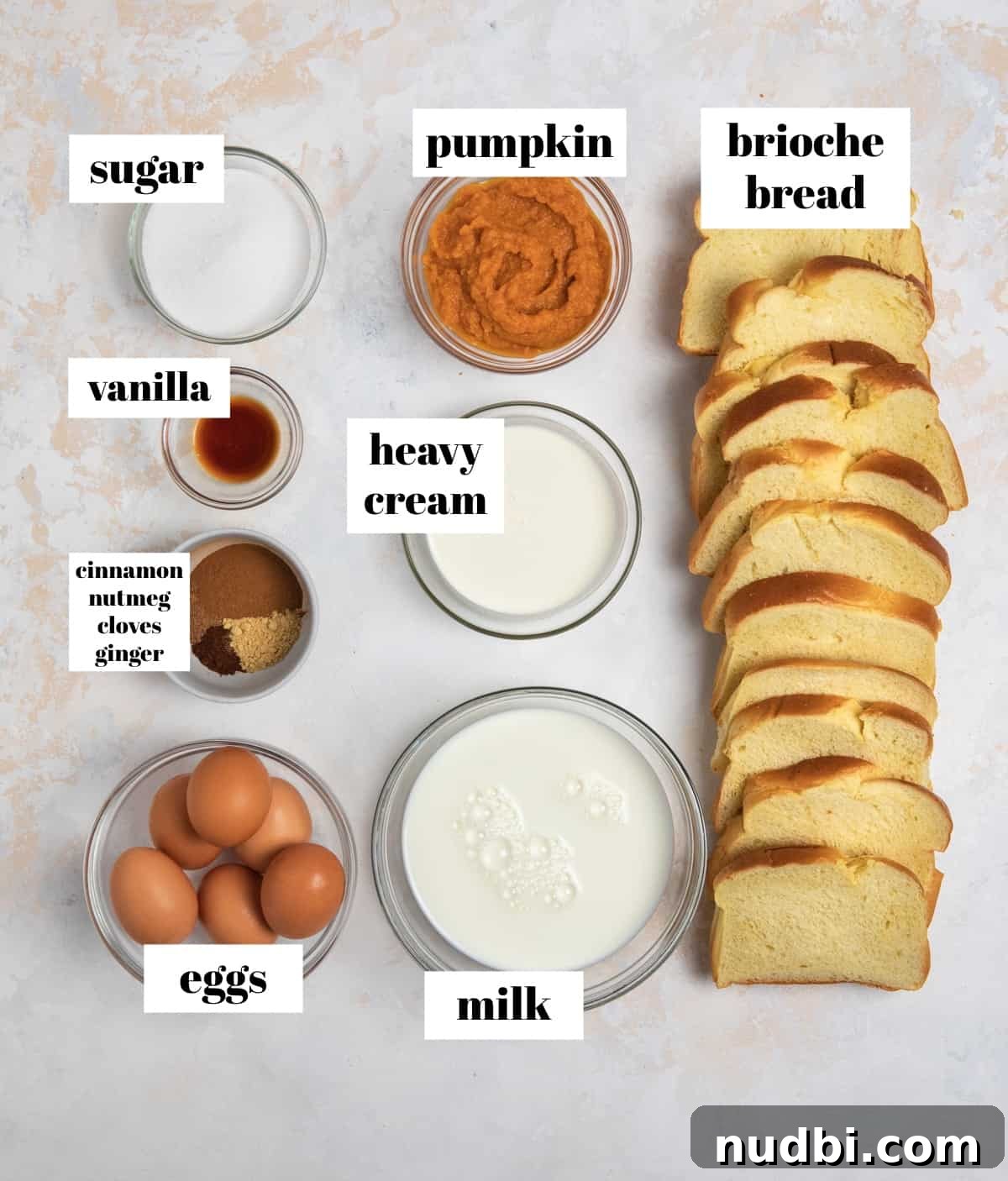 Pumpkin Spice French Toast Casserole Recipe for Fall Brunch 3 Eggs, milk, cream, spices, and other ingredients labeled on counter.