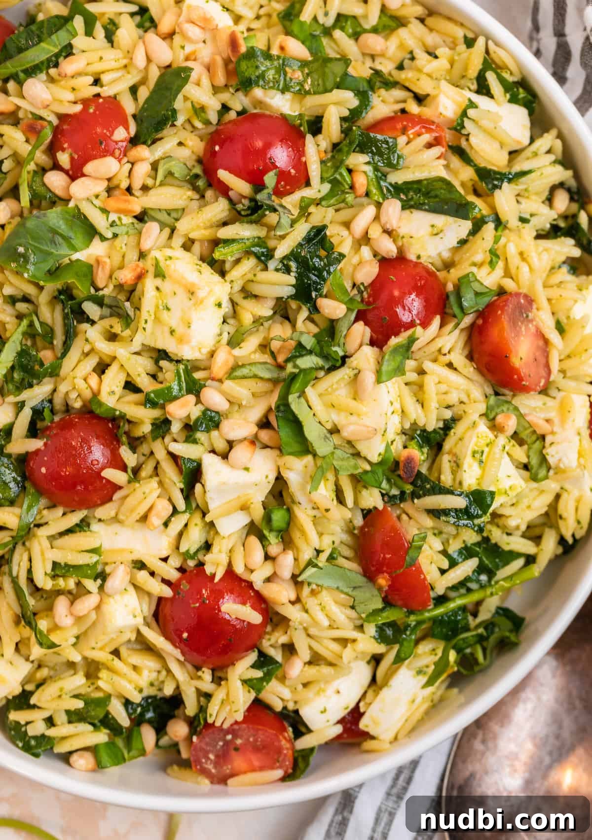 Creamy Pesto Orzo Salad with Cherry Tomatoes and Basil 10 White serving bowl with orzo salad with pesto.