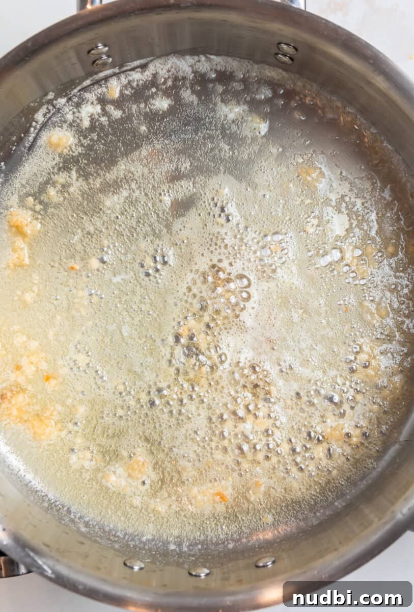 Crispy Pan-Fried Gnocchi with Garlic Butter and Parmesan 4 Butter and garlic cooking in pan.