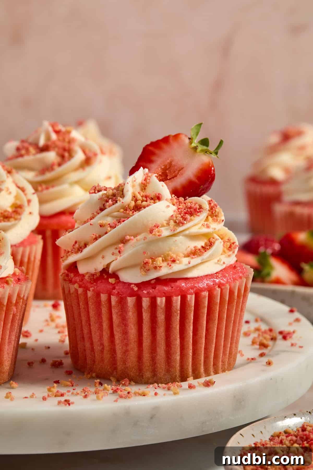 Strawberry Crunch Cupcakes with Crunchy Topping and Cream Cheese Frosting 2 Strawberry crunch cupcakes topped with strawberry slice for garnish.