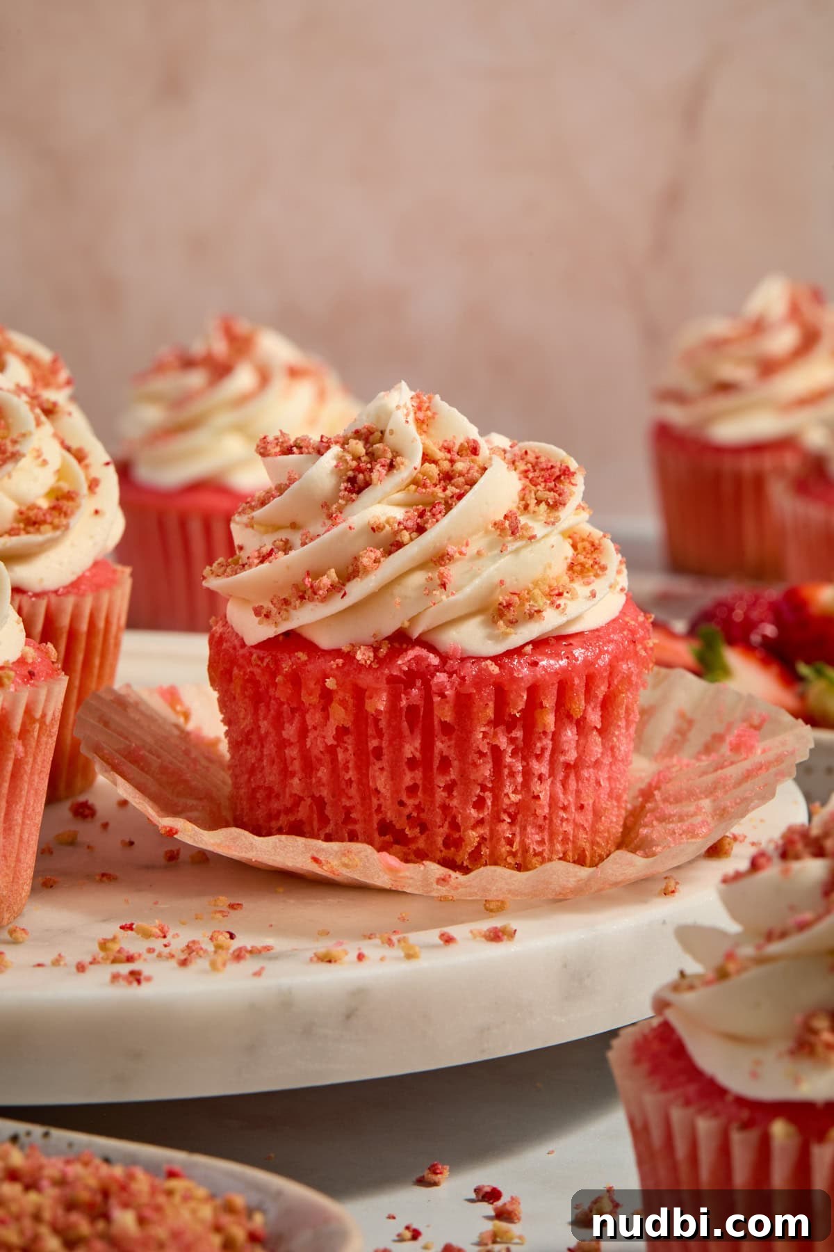 Strawberry Crunch Cupcakes with Crunchy Topping and Cream Cheese Frosting 13 Cupcakes arranged on tray with liner pulled down to show texture.