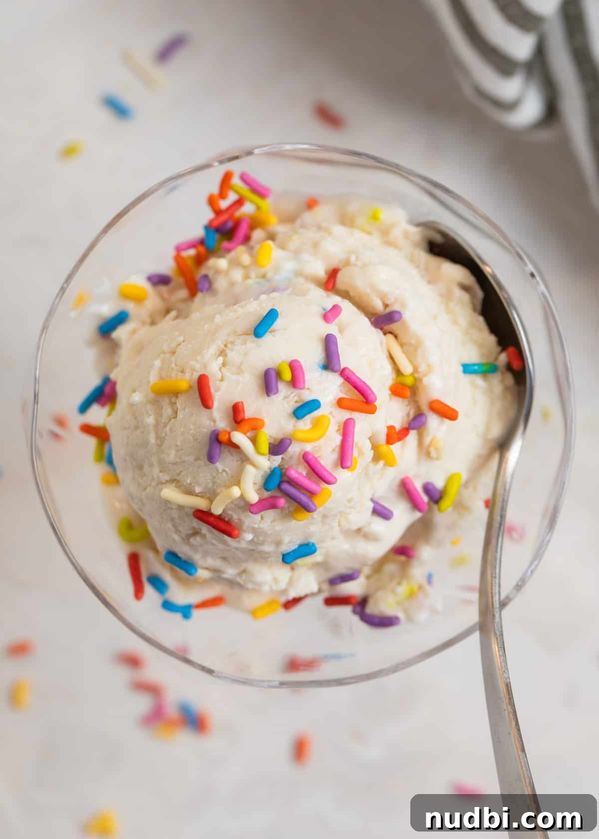 Creamy Cottage Cheese Ice Cream Recipe — Low-Sugar Frozen Dessert 2 Cottage cheese ice cream scooped in glass dish with sprinkles on top and spoon scooping in.