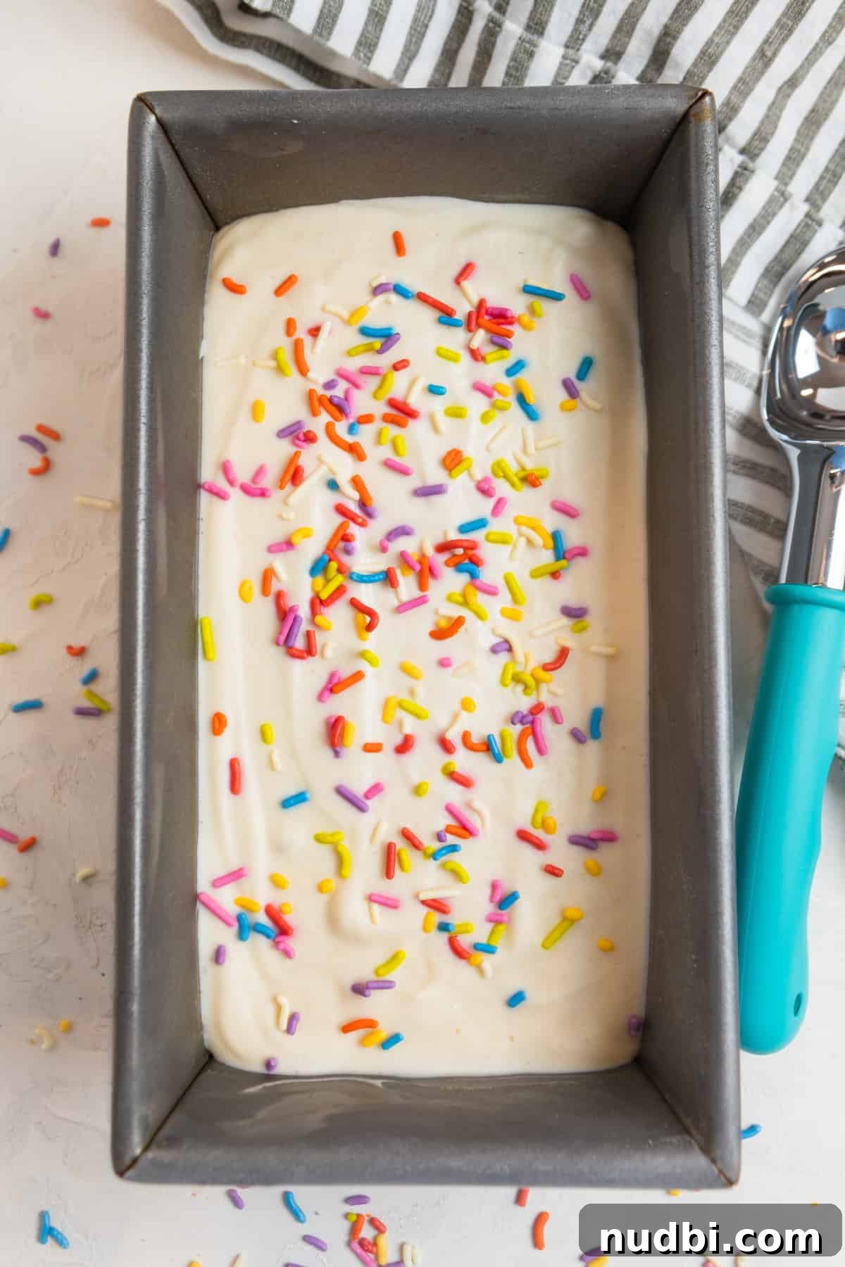 Creamy Cottage Cheese Ice Cream Recipe — Low-Sugar Frozen Dessert 11 Protein cottage cheese ice cream in loaf pan with ice cream scoop and sprinkles on top.