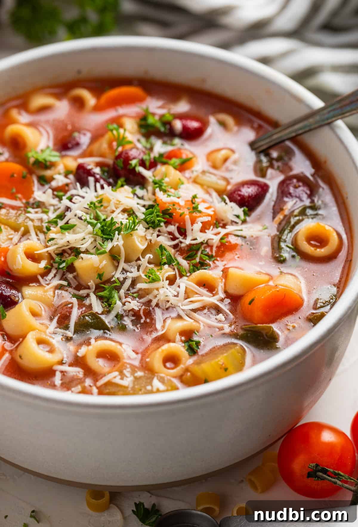 Hearty Chunky Italian Vegetable Soup Recipe 2 Bowl of chunky Italian vegetable soup with spoon and topped with parmesan and shredded parsley.